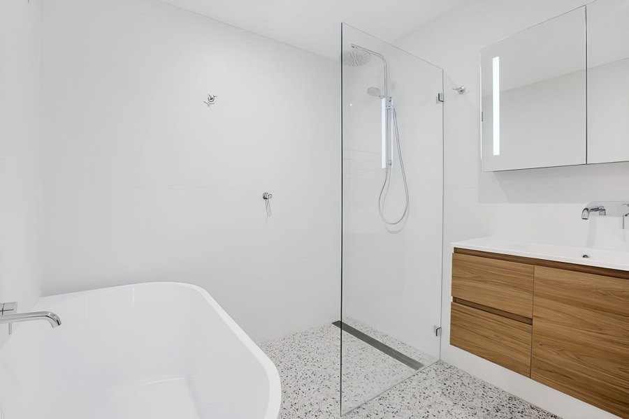 White bathroom with glass shower and bathtub