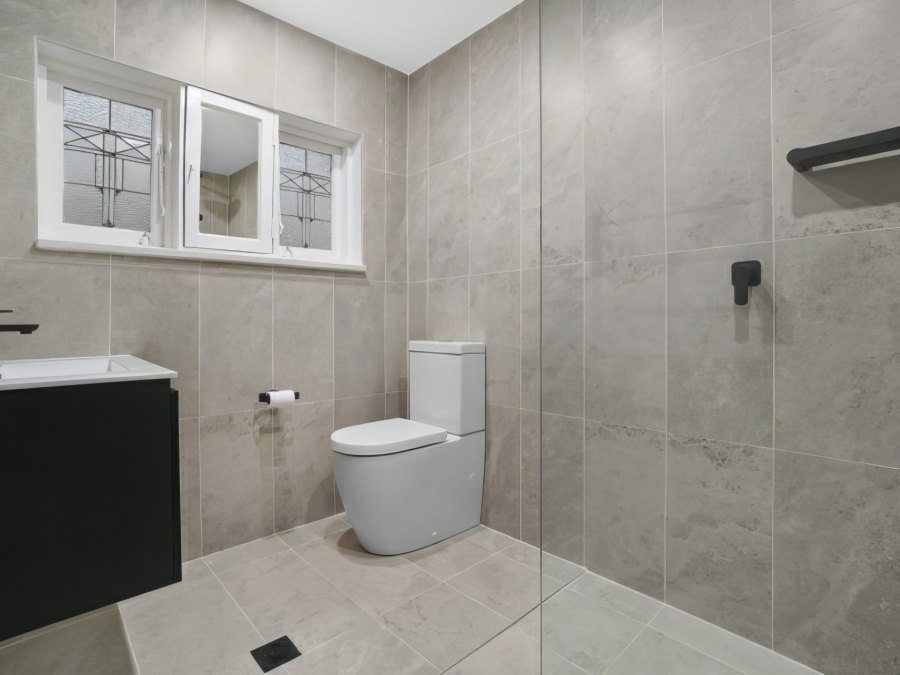 Modern bathroom with grey tiles and toilet