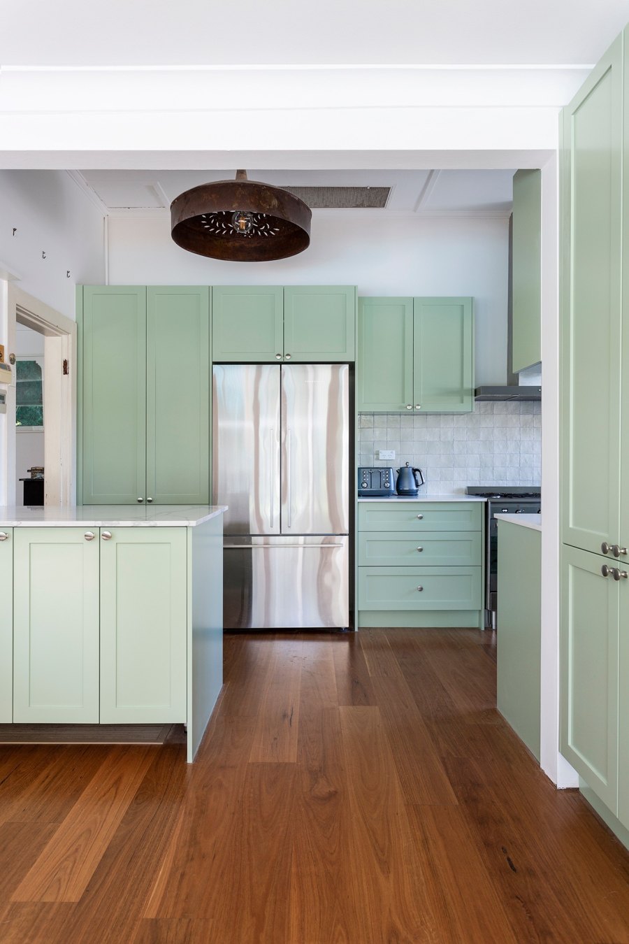 Spacious kitchen with green cabinetry