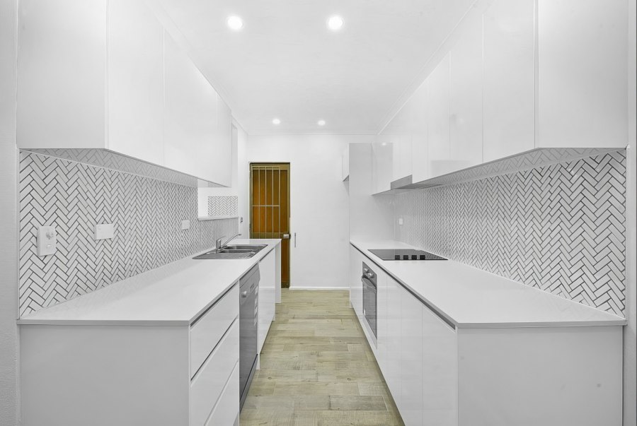 White kitchen with herringbone tile backsplash