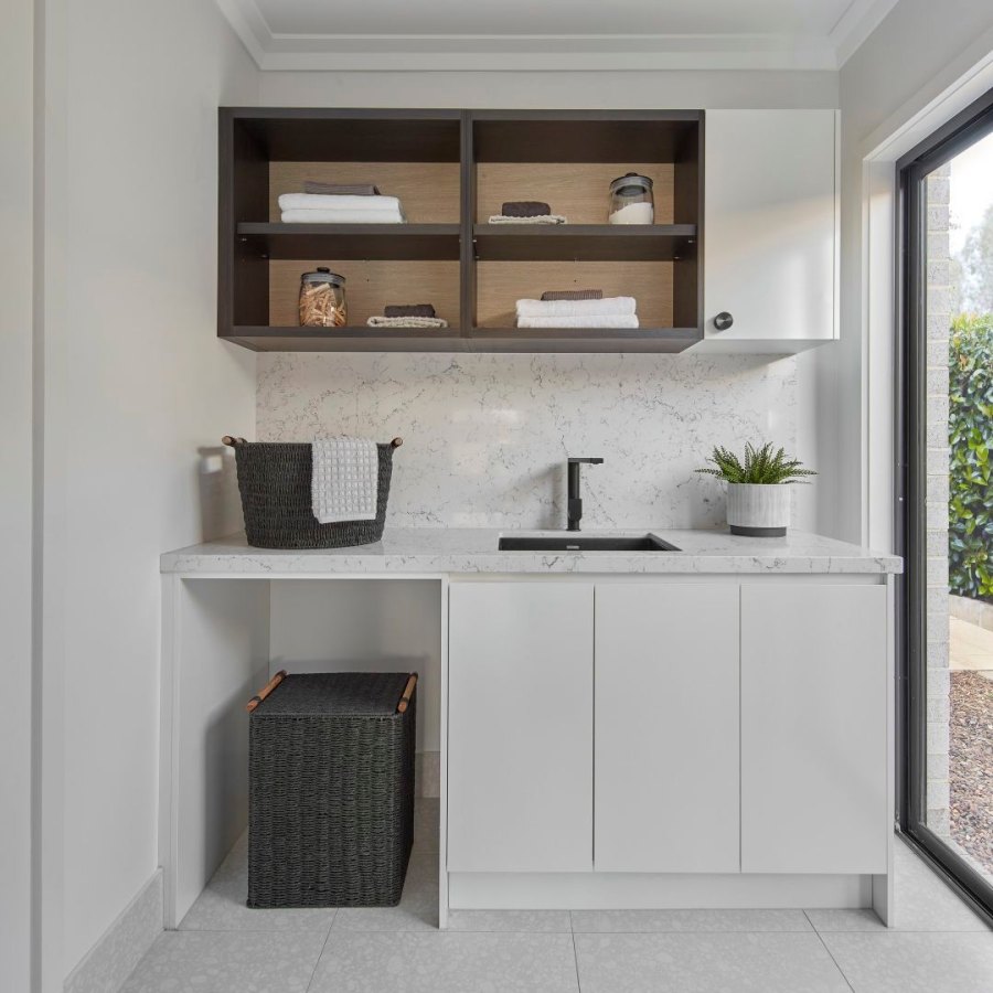 Stylish laundry room with open shelving and black sink.