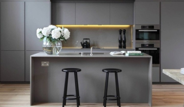 Modern laundry room renovation with custom cabinetry and stylish backsplash