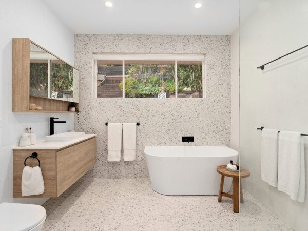 Modern bathroom renovation with freestanding tub and sleek black fixtures