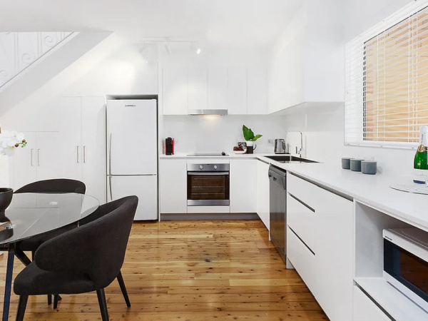 Modern laundry room renovation with custom cabinetry and stylish backsplash