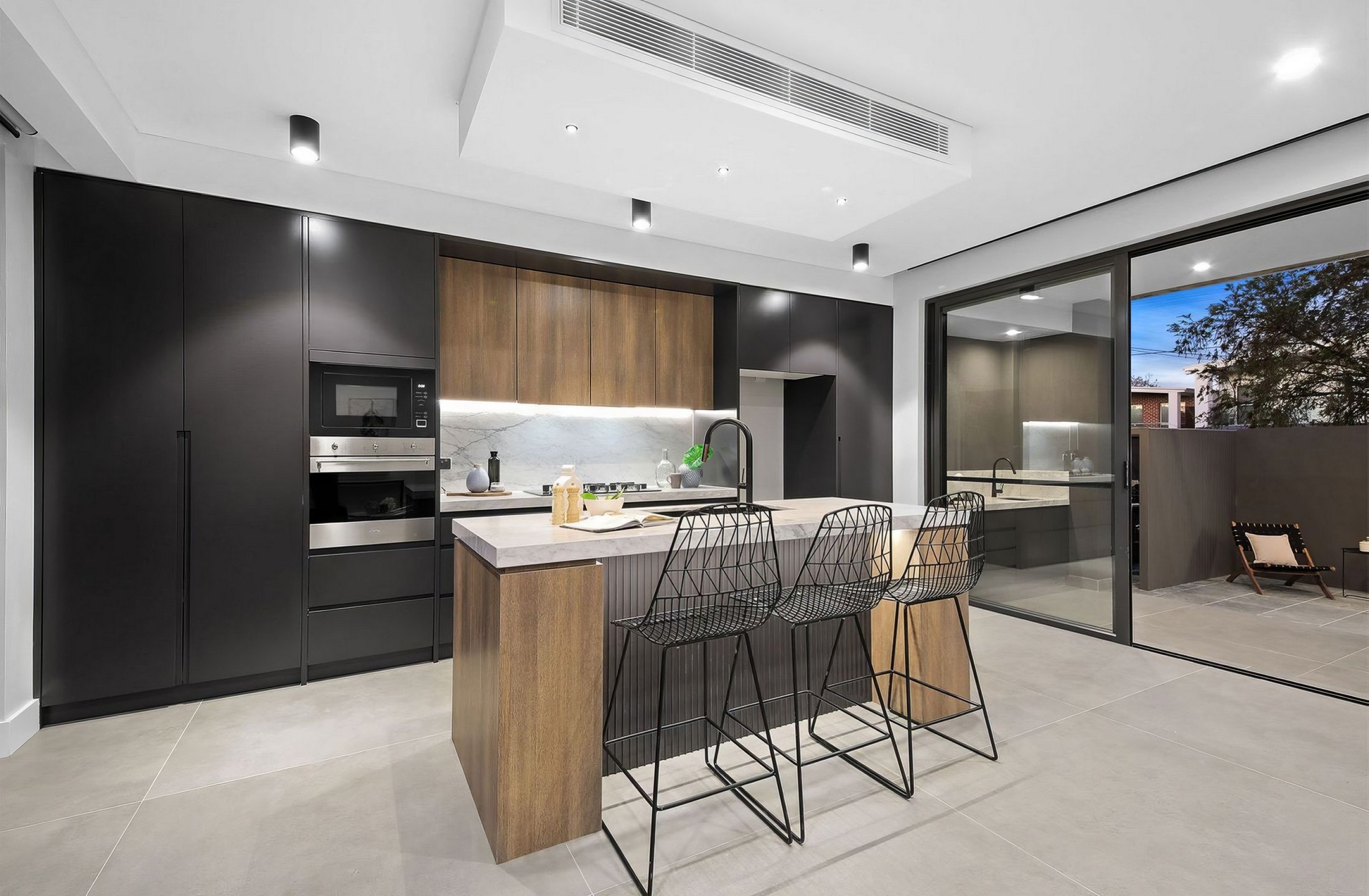 Modern kitchen renovation with island seating and sleek black cabinetry